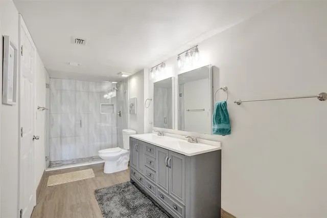 a spacious bathroom with a double vanity sink toilet and shower