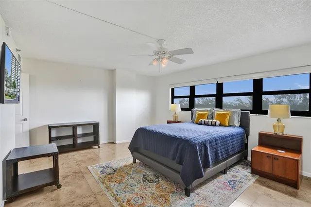 a bedroom with a bed a stove and potted plant on the dresser