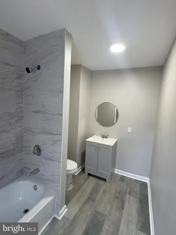 a bathroom with a tub sink and mirror