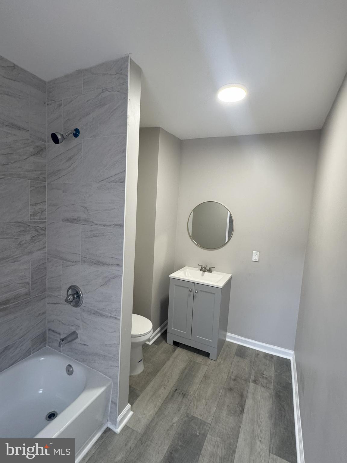 a bathroom with a tub sink and mirror