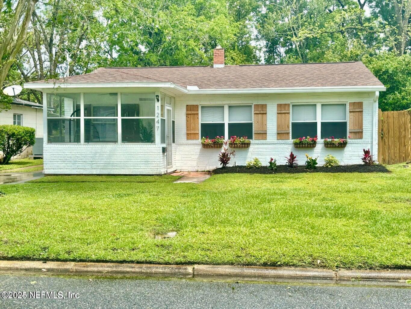 a front view of a house with a yard and seating space