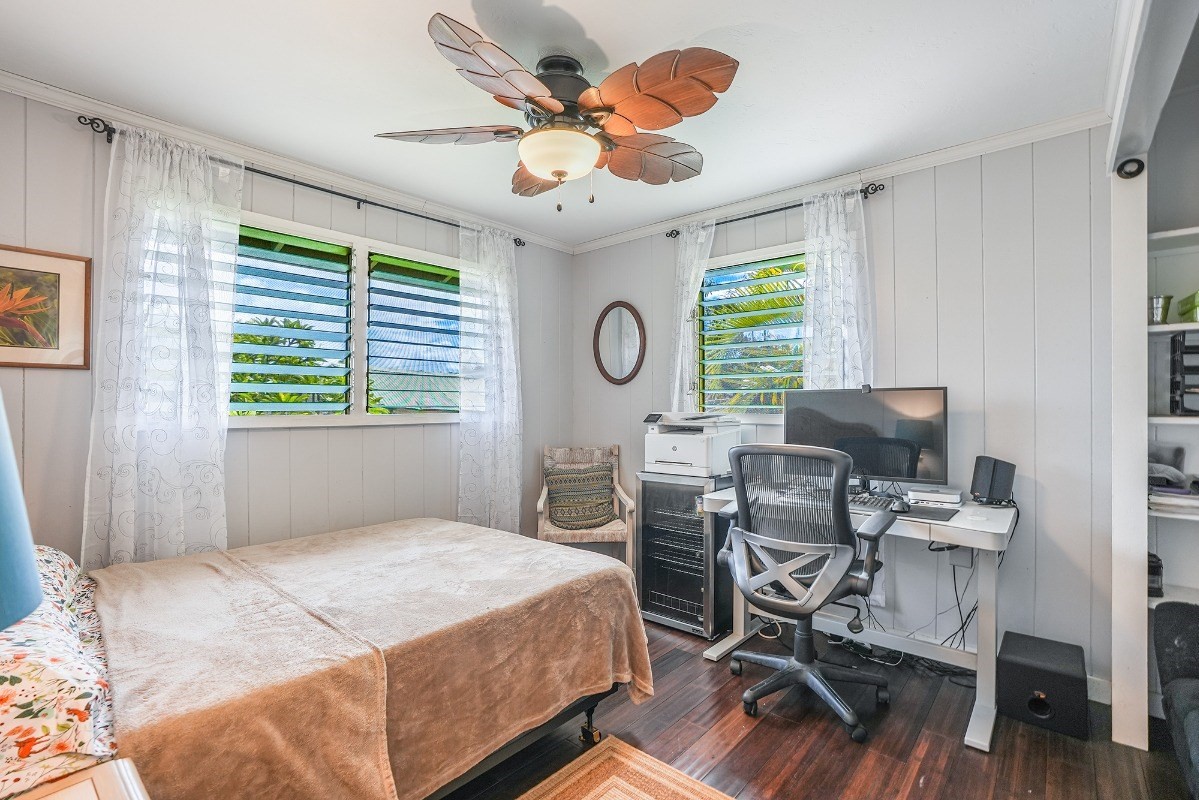 8778 Kekaha Road Kekaha, HI 96752 - Photo 11 of 18 a bedroom with a bed and a chandelier