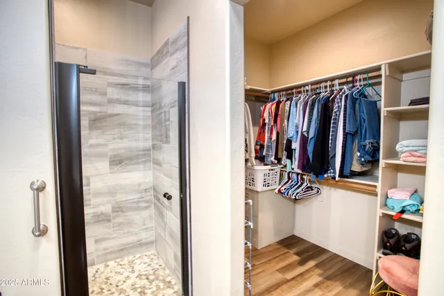 a view of walk in closet with clothes and shoes