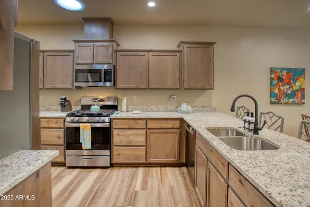 a kitchen with stainless steel appliances granite countertop a sink stove and refrigerator