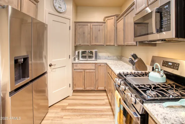 a kitchen with stainless steel appliances granite countertop a stove and a refrigerator