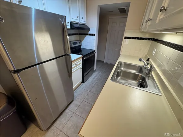 a kitchen with a refrigerator and a sink