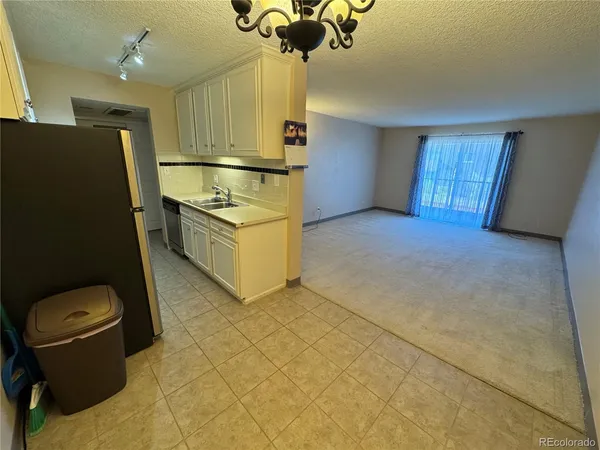 a kitchen with stainless steel appliances a stove a refrigerator a sink a microwave oven and a dining table