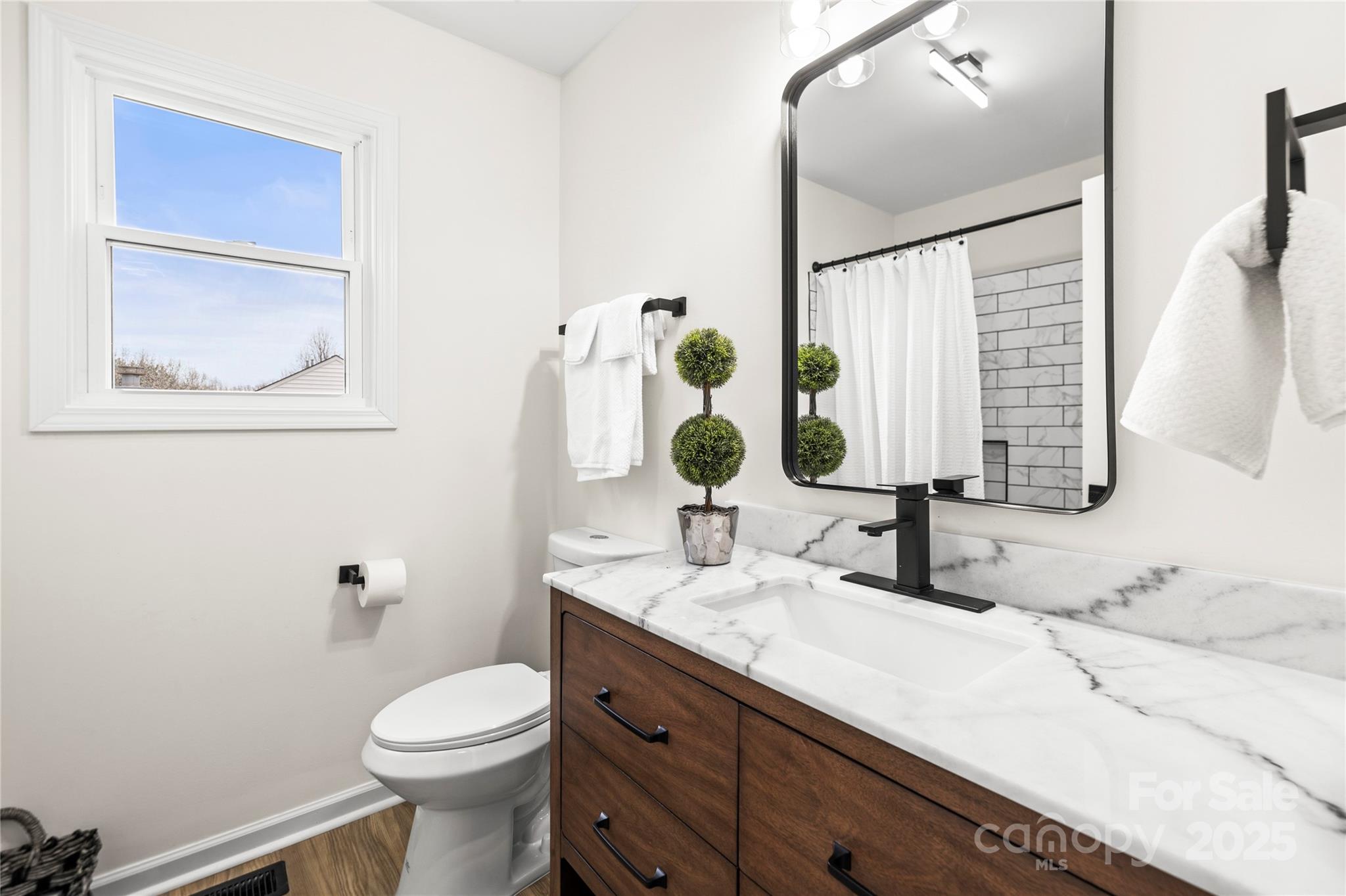 10211 Ridgewell Court Charlotte, NC 28215 - Photo 34 of 41 a bathroom with a granite countertop toilet sink and mirror