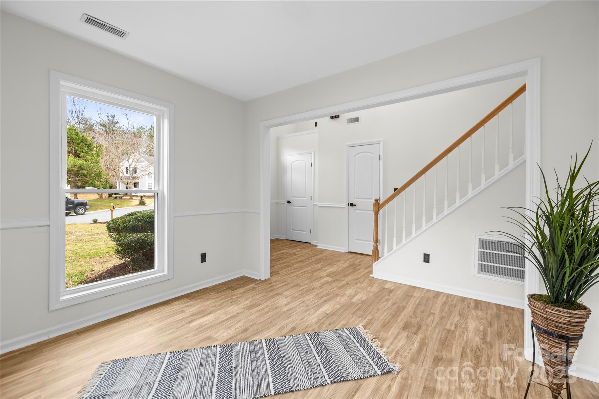 10211 Ridgewell Court Charlotte, NC 28215 - Photo 6 of 41 a view of an empty room with wooden floor and a window