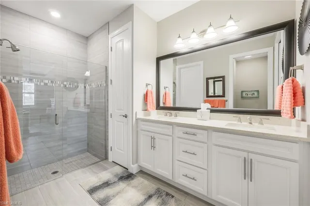a bath room with a double vanity sink mirror and shower