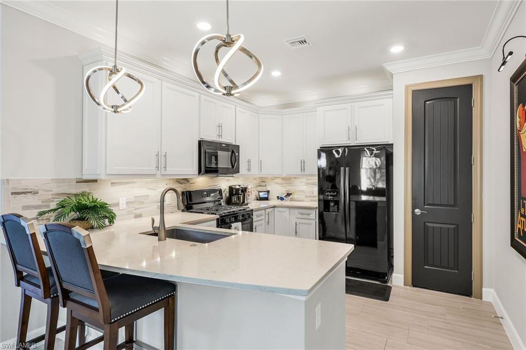 20022 Parrot Key Court Estero, FL 33928 - Photo 4 of 31 a kitchen with stainless steel appliances granite countertop a sink a stove a refrigerator cabinets and a dining table