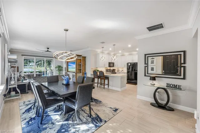 a view of a dining room and livingroom with furniture a rug a painting and a chandelier