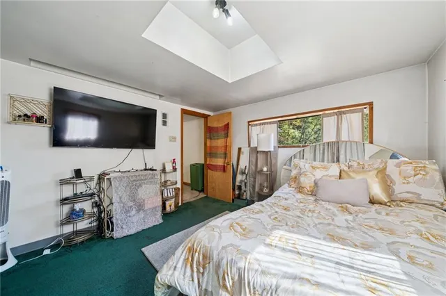 a bedroom with a bed television window and a flat screen television