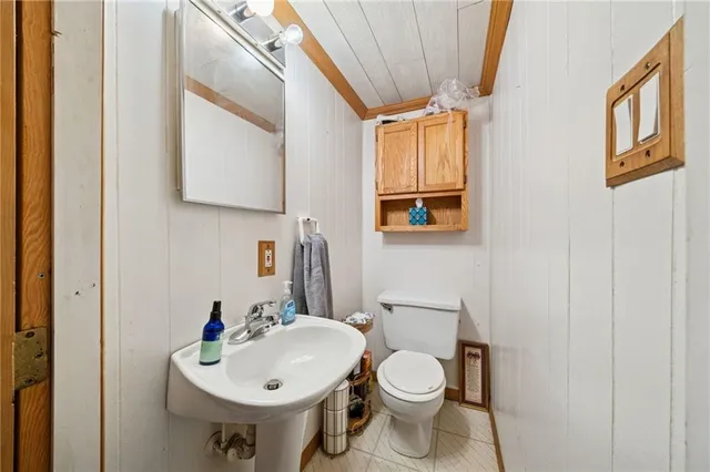 a bathroom with a sink toilet and mirror