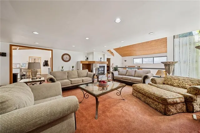 a living room with furniture kitchen view and a large window