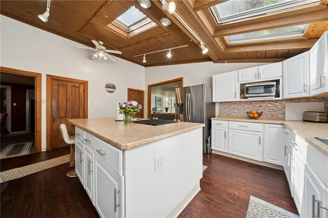 a kitchen with granite countertop a sink appliances cabinets and a counter top space