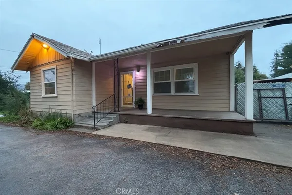 a backyard of a house with barbeque oven table and chairs