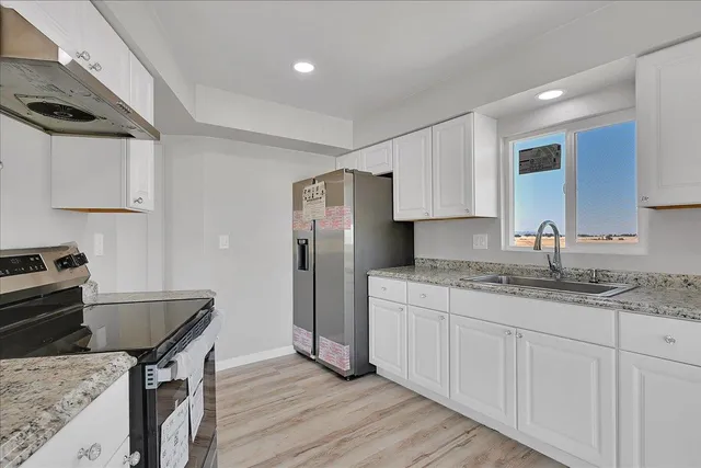 a kitchen with stainless steel appliances granite countertop a stove a sink and a refrigerator