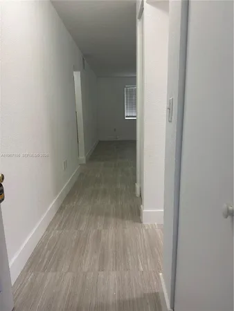 a view of a small space with wooden floor and a hallway
