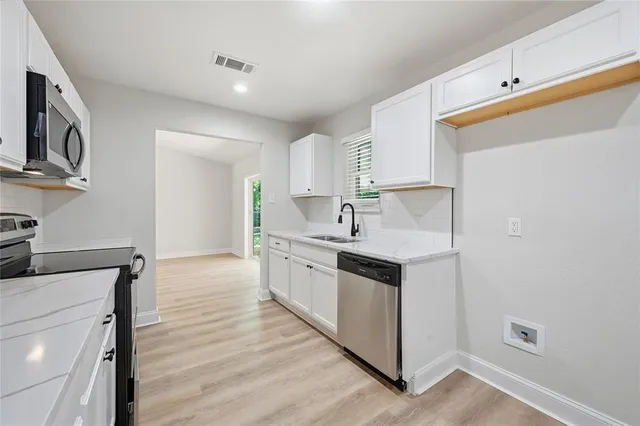 a kitchen with stainless steel appliances granite countertop a sink and a stove top oven