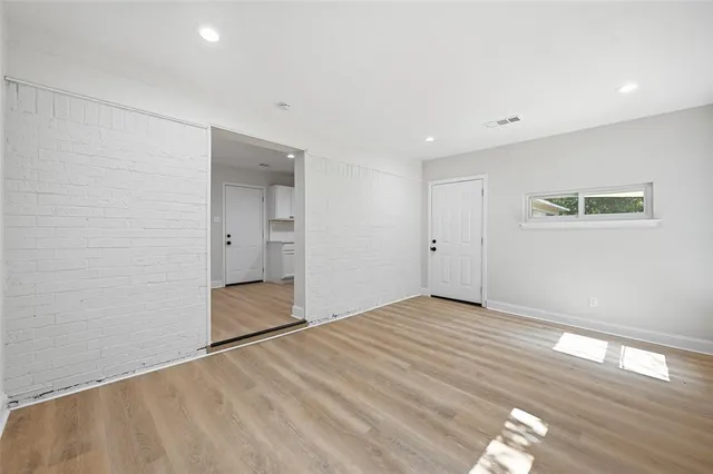 a view of an empty room with wooden floor