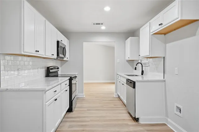 a kitchen with stainless steel appliances granite countertop a sink and dishwasher a stove top oven