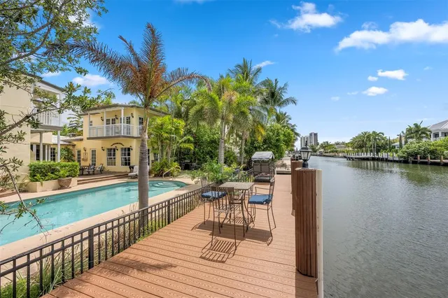 a view of a chairs and table on the wooden deck with a lake view