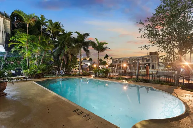 a view of a swimming pool with a lawn chairs under an umbrella