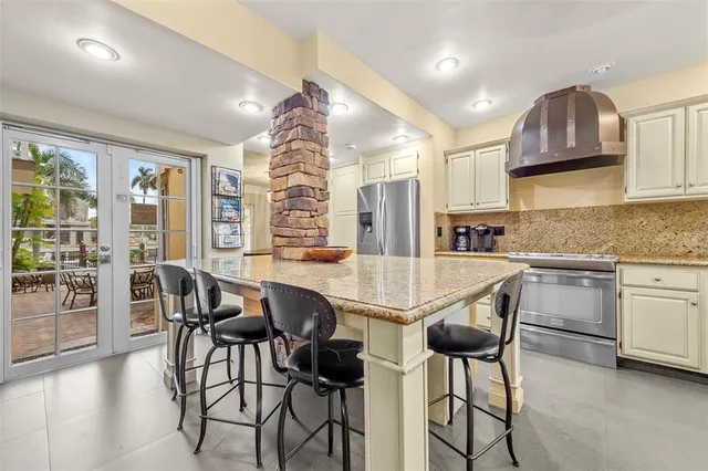 a kitchen with granite countertop a table chairs stove and cabinets