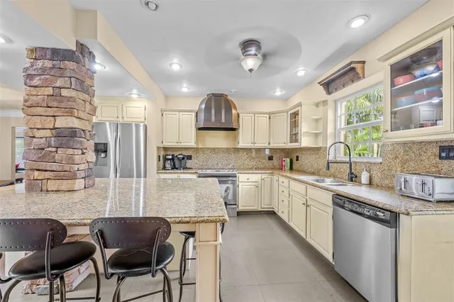 a large white kitchen with lots of counter space cabinets and appliances