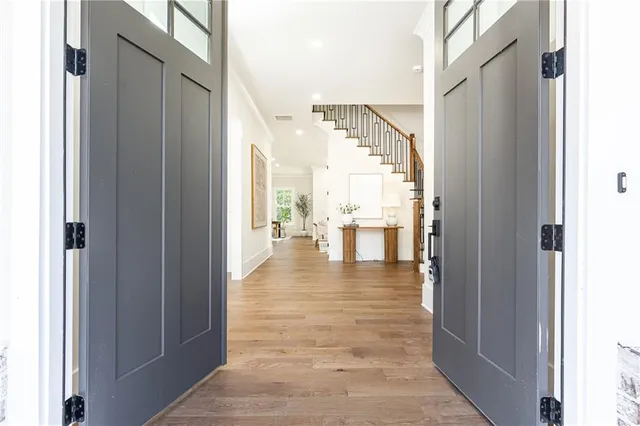 a view of a hallway with wooden floor and a living room