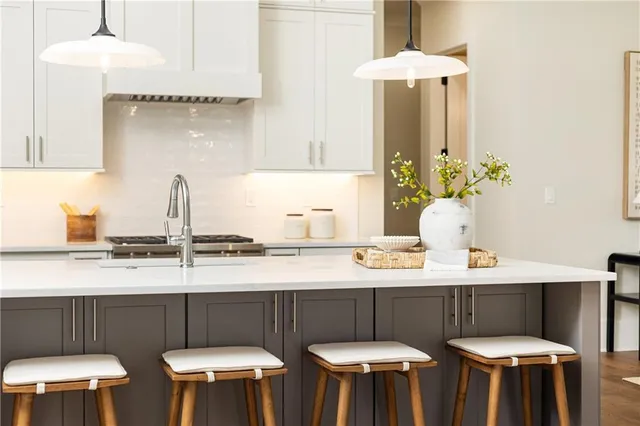 a kitchen with stainless steel appliances a dining table chairs stove and kitchen view