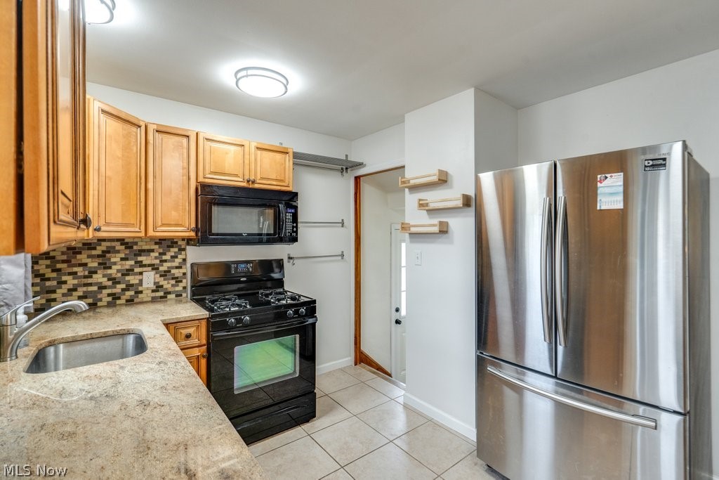 30000 Elgin Road Wickliffe, OH 44092 - Photo 2 of 30 Kitchen featuring light wood cabinetry, a mosaic tile backsplash, and a stainless steel refrigerator