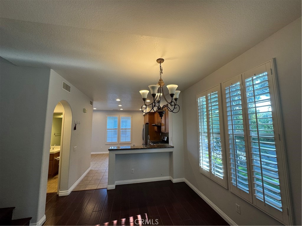211 Tall Oak Irvine, CA 92603 - Photo 5 of 12 a room with chandelier and wooden floor
