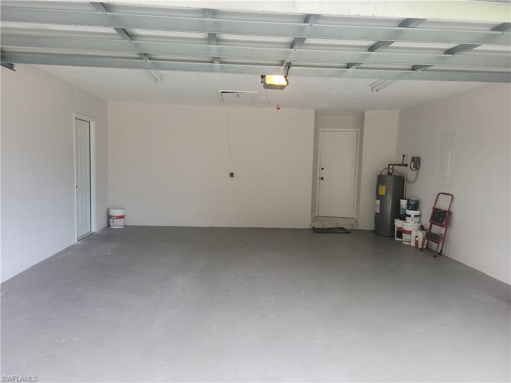 735 High Pines Drive Naples, FL 34103 - Photo 26 of 30 Garage featuring a garage door opener and water heater