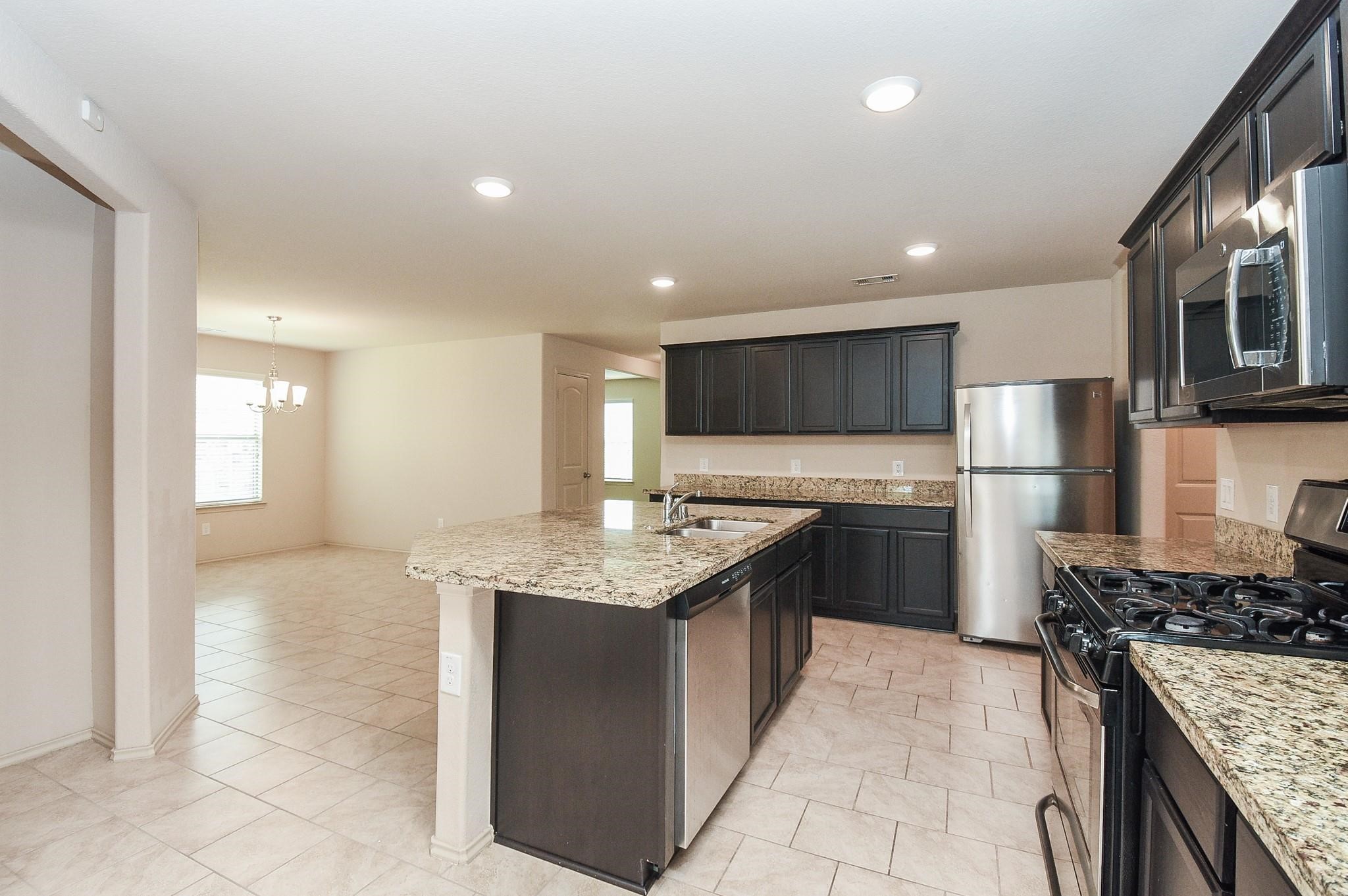 23306 Joyful Way Spring, TX 77373 - Photo 11 of 32 a kitchen with a stove a refrigerator and a sink