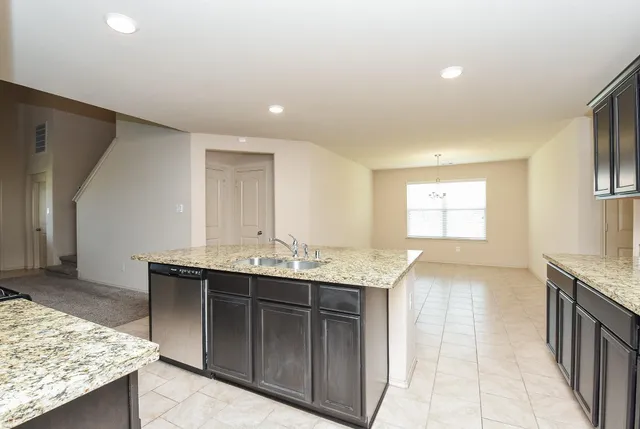 a kitchen with granite countertop a sink and a stove