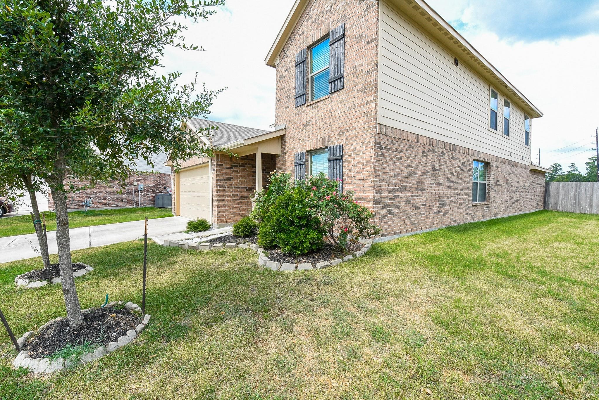 23306 Joyful Way Spring, TX 77373 - Photo 2 of 32 a view of a house with a yard and a large tree