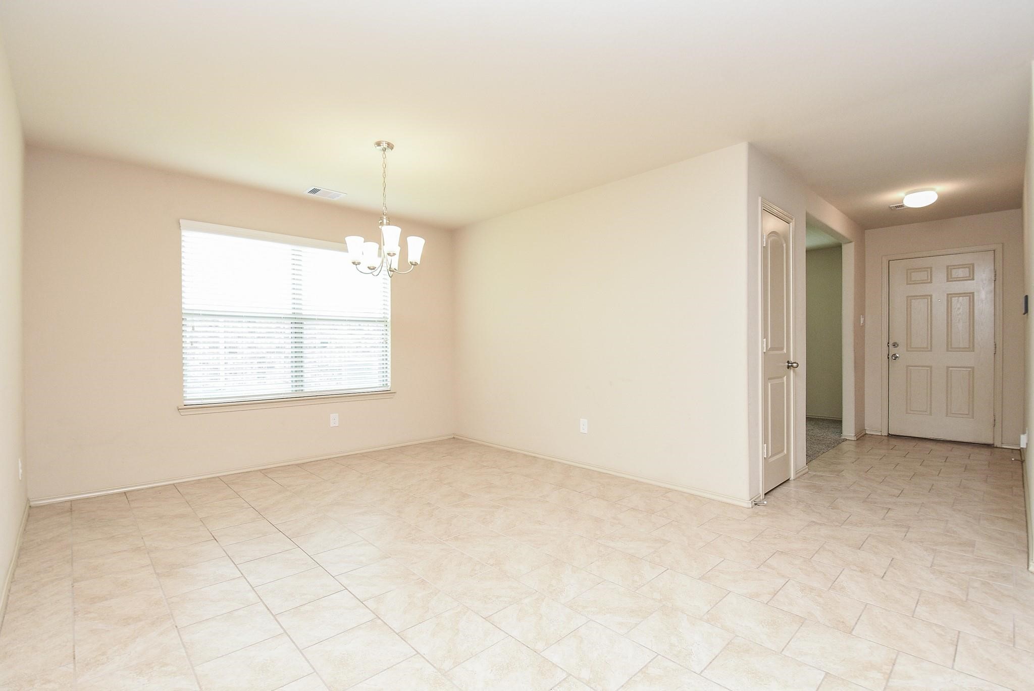 23306 Joyful Way Spring, TX 77373 - Photo 6 of 32 an empty room with windows and chandelier fan