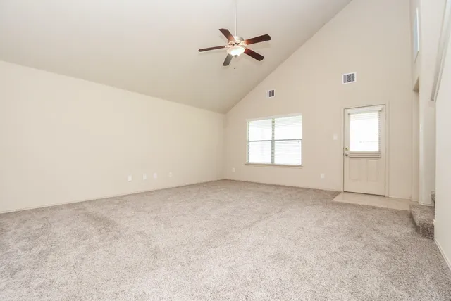 an empty room with fan and windows