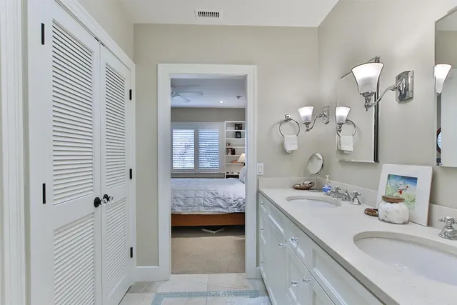 a en suite bathroom with a double vanity sink and a mirror