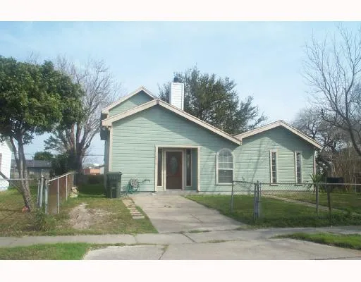 a view of a yard in front of a house with large windows