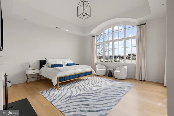 a spacious bedroom with a bed and wooden floor
