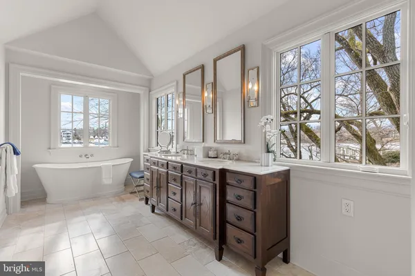 a bathroom with a granite countertop sink and a bathtub