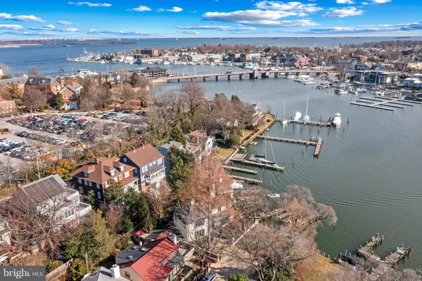an aerial view of a city with lots of residential buildings ocean and mountain view in back