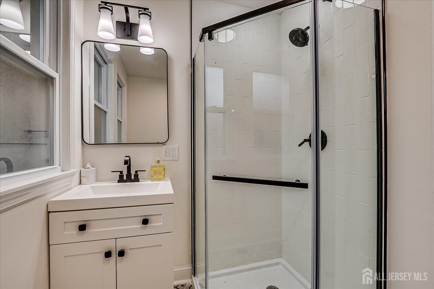 140 Oakview Avenue Maplewood, NJ 07040 - Photo 38 of 67 a bathroom with a shower sink vanity and mirror