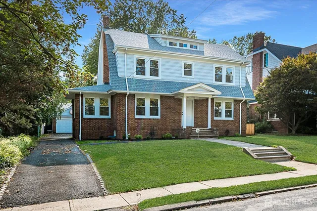 a view of a house with a yard and sitting area