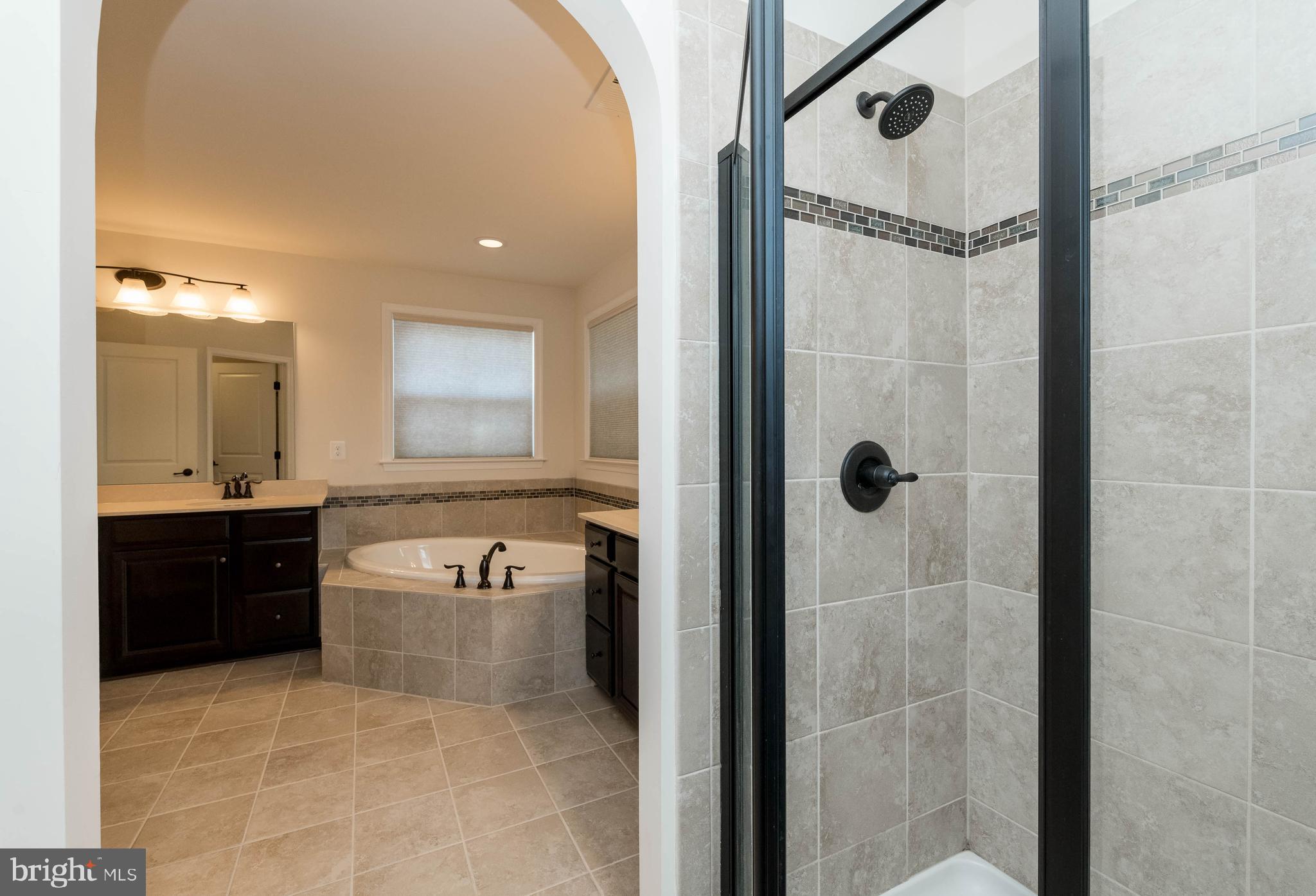 4207 Perry Hall Road Perry Hall, MD 21128 - Photo 37 of 53 a bathroom with a granite countertop sink a mirror a bathtub and shower