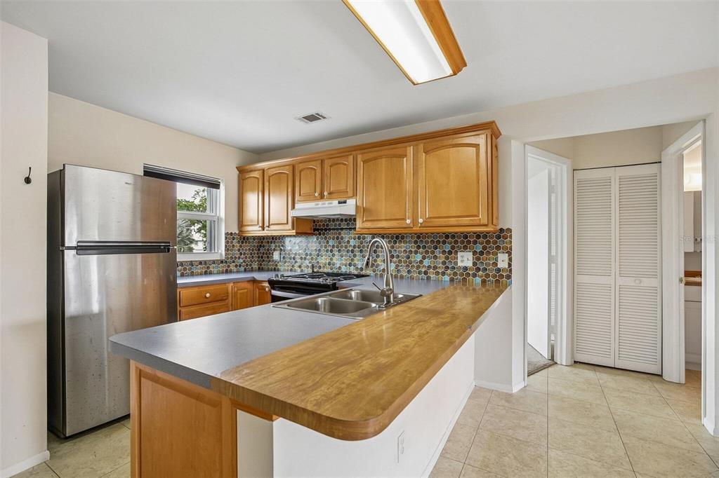 26485 Rampart Boulevard, Unit A27 Punta Gorda, FL 33983 - Photo 23 of 27 a kitchen with refrigerator and cabinets