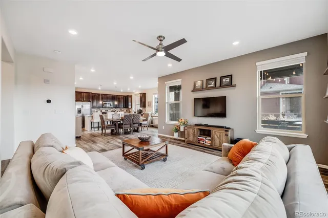 a living room with furniture ceiling fan and a flat screen tv